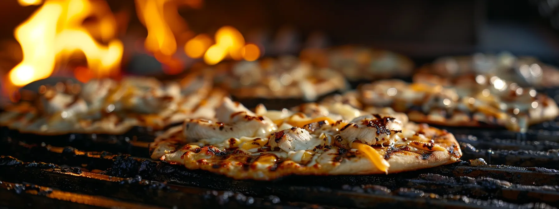 grilled chicken and cheddar cheese melting on flatbread pizzas ready to be grilled.